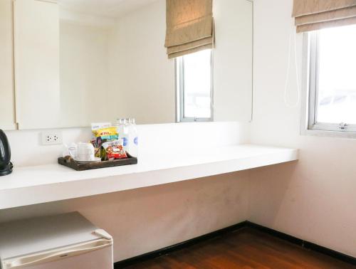 曼谷叻差达迷你R酒店的厨房里的一个白色的柜台,有窗户