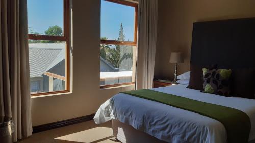 奥茨胡恩Karoo Sun Boutique Guest House的一间卧室设有一张床和一个大窗户