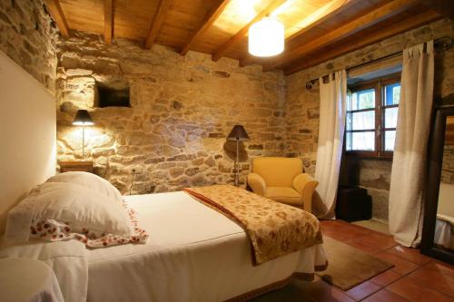 Pidre帕拉达达斯贝斯塔斯乡村民宿的一间卧室设有一张床和石墙