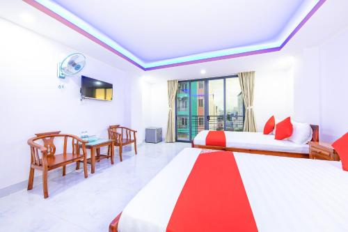 芽庄Q3 Viet An Hotel Nha Trang的酒店客房设有两张床和一张桌子。
