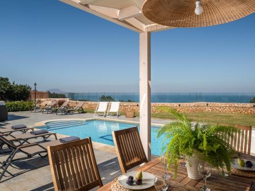 杰拉尼Anemolia Seaview Villa, with private Pool & Garden, By ThinkVilla的一个带桌椅的庭院和一个游泳池