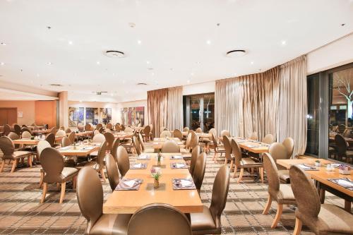 比勒陀利亚RH Hotel Pretoria的用餐室配有木桌和椅子