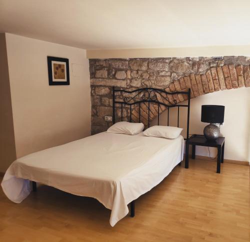 曼雷沙乌尔比公寓的一间卧室设有一张床和石墙