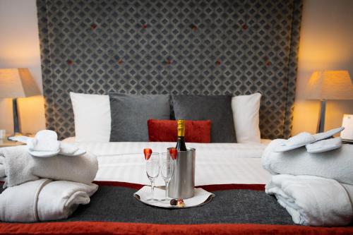 大莫尔文马尔文酒店的酒店客房,配有带毛巾和酒杯的床