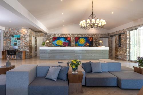 瓦西里亚斯Kassandra Bay Resort, Suites & Spa的客厅配有蓝色的沙发和吊灯。