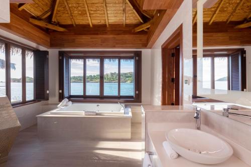 Five Islands VillageRoyalton Antigua, An Autograph Collection All-Inclusive Resort的带浴缸和盥洗盆的大浴室