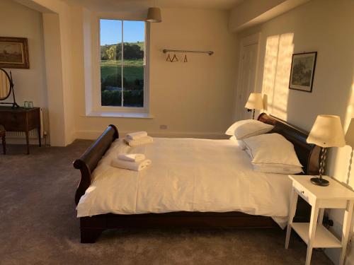 勒德洛Caynham Court的卧室配有一张带白色床单的大床和窗户。