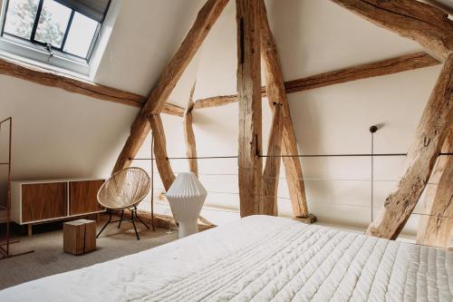 吉维尼拉迪米迪吉维尼度假屋的卧室设有白色的床和木梁。