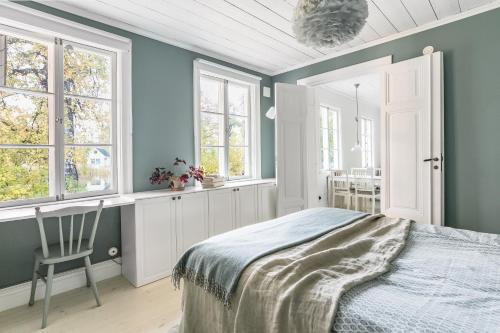 斯德哥尔摩Peaceful, Picturesque Lake & Forest Retreat的一间卧室设有蓝色的墙壁和一张带椅子的床