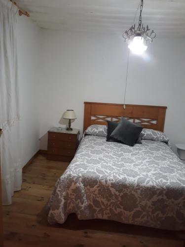 CaselaCasa Da Carme的一间卧室配有一张床和一个吊灯