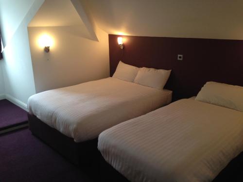 布莱克本山景酒店的配有白色床单的酒店客房内的两张床