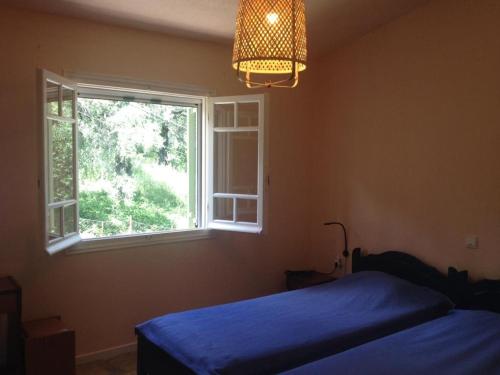 科孚镇Maria Corfu Loustri的一间卧室设有蓝色的床和窗户。