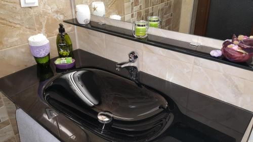 普罗夫迪夫Art House Plovdiv的浴室内的一个黑色水槽,配有镜子