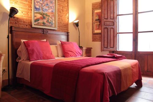 塔拉韦拉·德·拉·雷纳德拉格拉里雅可登宾馆的一间卧室配有一张带红色毯子的大床