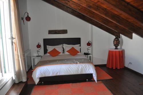 阿尔维图Horta Da Vila的一间卧室配有带橙色枕头的床