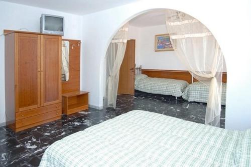 佩斯基奇罗坎达城堡旅馆的一间卧室设有两张床和一个拱形门廊。