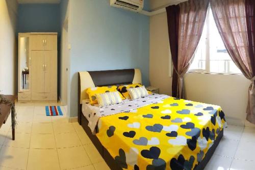 拉布安DinDas Family Stay @ Labuan的一间卧室配有一张黄色和蓝色的被子。