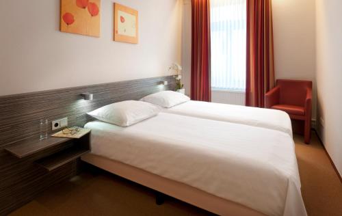 埃彭古达尔公寓酒店的酒店客房设有一张大床和一张红色椅子。