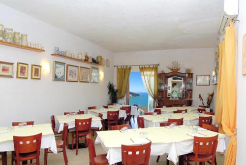 佩斯基奇罗坎达城堡旅馆的用餐室配有白色的桌子和红色的椅子