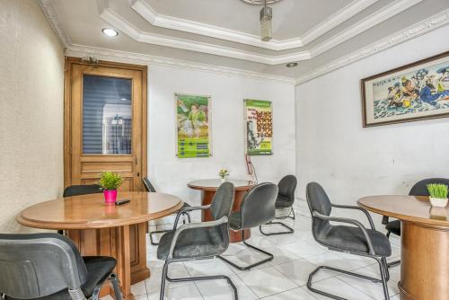 雅加达RedDoorz Hostel @ Feliz Noche Cengkareng的一间会议室,配有两张桌子和椅子