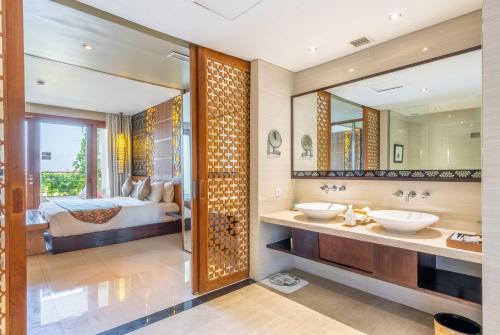 努沙杜瓦VOUK Hotel and Suites Nusa Dua Bali的浴室设有2个水槽,床位于后面。