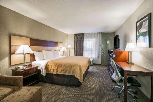 尤福拉Quality Inn & Suites near Lake Eufaula的酒店客房,配有床和沙发