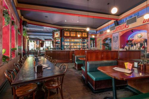 悉尼Hotel Harry, Ascend Hotel Collection的一间带桌椅的餐厅和一间酒吧