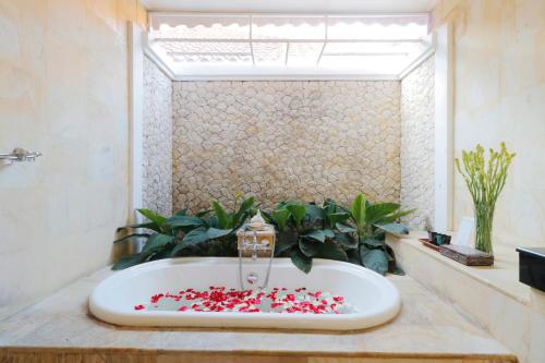 塞米亚克海里康别墅酒店的一间带浴缸的浴室,里面装满红色的心脏