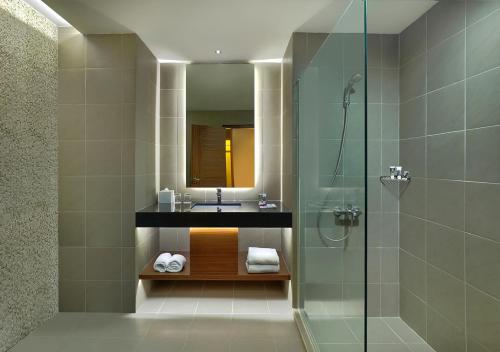 美娜多Manado Tateli Resort and Convention的一间带水槽和玻璃淋浴的浴室