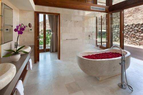 埃拉特Herbert Samuel Royal Shangri-La Eilat的浴室配有装满红花的浴缸。