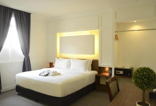 马六甲碧兰精品酒店的酒店客房配有一张床铺和一张桌子。