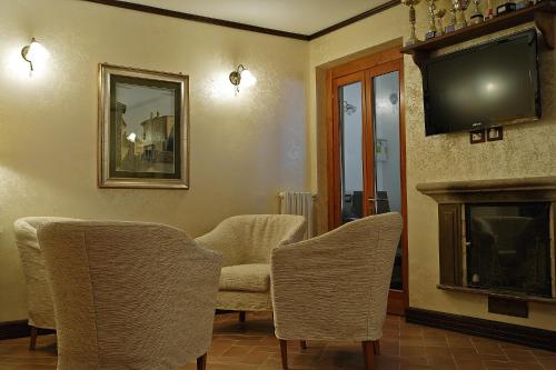 佩斯科克斯坦佐B&B IL PINO的客厅配有椅子、电视和壁炉