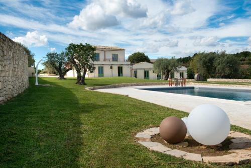 诺托Relais Terre di Romanello的一座房子,设有游泳池和草坪上的两个鸡蛋