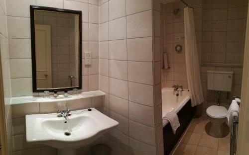 布莱克浦布莱克浦帝国酒店的一间带水槽、浴缸和卫生间的浴室