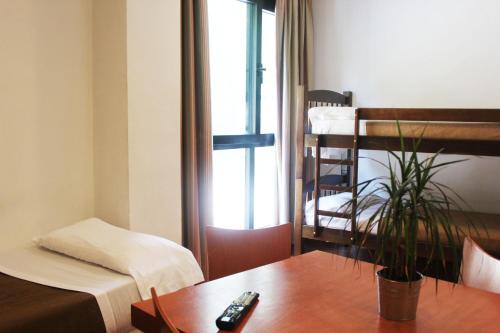 塞拉内华达Apartamentos Montegorbea的一间设有床和一张带遥控器的桌子的房间