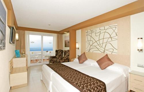 米乔尔海滩Riu La Mola的酒店客房设有一张床,享有海景。