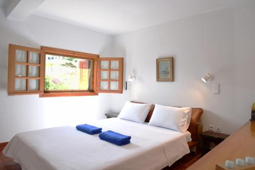 阿纳维索斯Villa Falmy的卧室配有白色床和2条蓝色毛巾