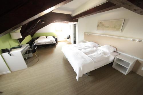 普朗然阿尔贝其普拉金斯酒店的酒店客房带两张床、一张书桌和一间卧室