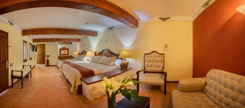 瓦哈卡市Hotel Casa Barrocco Oaxaca的配有一张床和一把椅子的酒店客房
