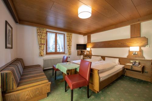 圣安东阿尔贝格加姆伯格酒店的酒店客房配有一张床铺和一张桌子。