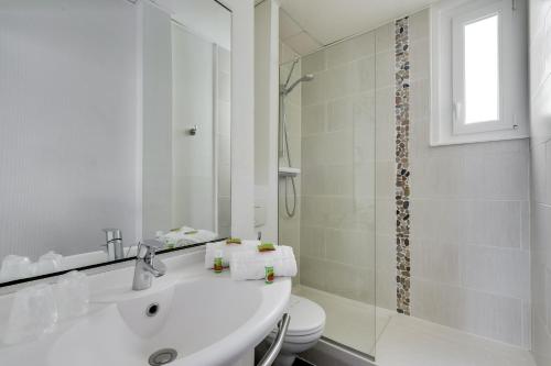 里尔Hotel Chagnot的白色的浴室设有水槽和淋浴。