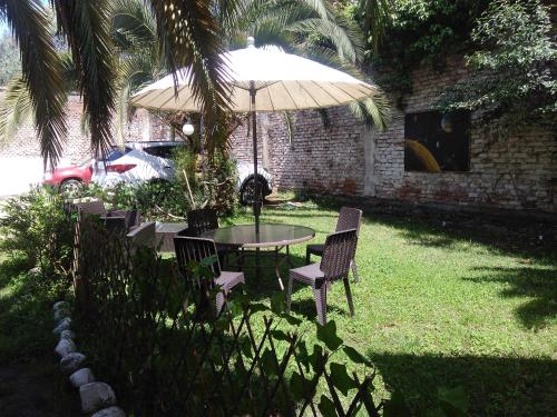 塔尔卡Hostal Del Centro Talca的院子里伞下的桌子和椅子