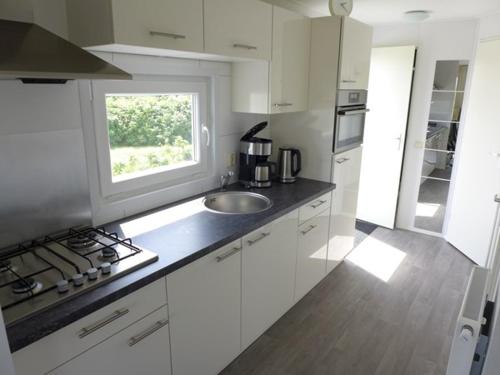 BeekChalet Helmgras的白色的厨房设有水槽和窗户