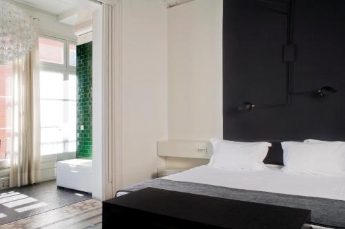 巴塞罗那兰布拉普拉提克酒店的卧室配有白色的床和黑色墙壁