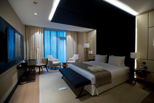布拉柴维尔Grand Hotel de Kintele的一间带大床的卧室和一间客厅