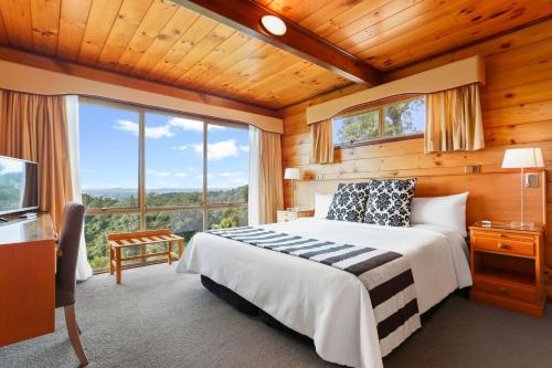 奥克兰Waitakere Resort & Spa的一间卧室设有一张床和一个大窗户