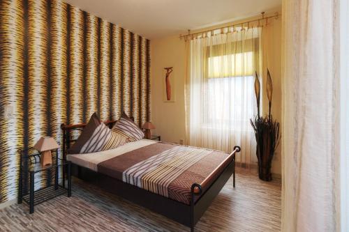 贝尔恩卡斯特尔-库斯Mosella Ferienwohnungen的一间卧室设有一张床和一个窗口