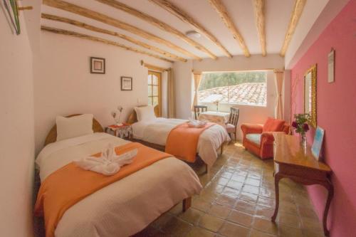 奥兰太坦波帕尔瓦旅馆的带三张床、椅子和窗户的房间