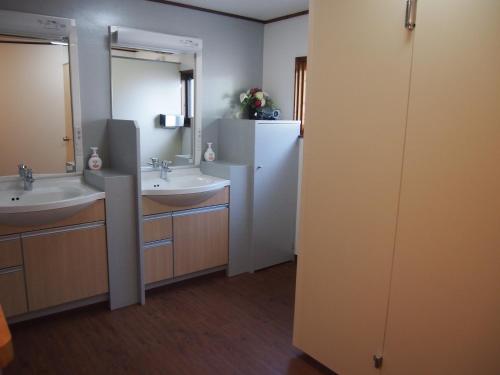 鹤冈市羽黒馆酒店的浴室设有2个水槽和2面镜子