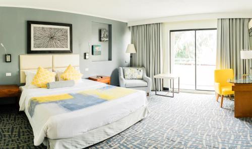 加拉班世纪大酒店的酒店客房带一张大床和一把椅子